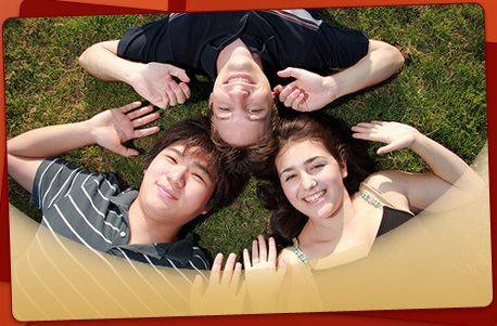 stock photo of 3 teens lying on the grass